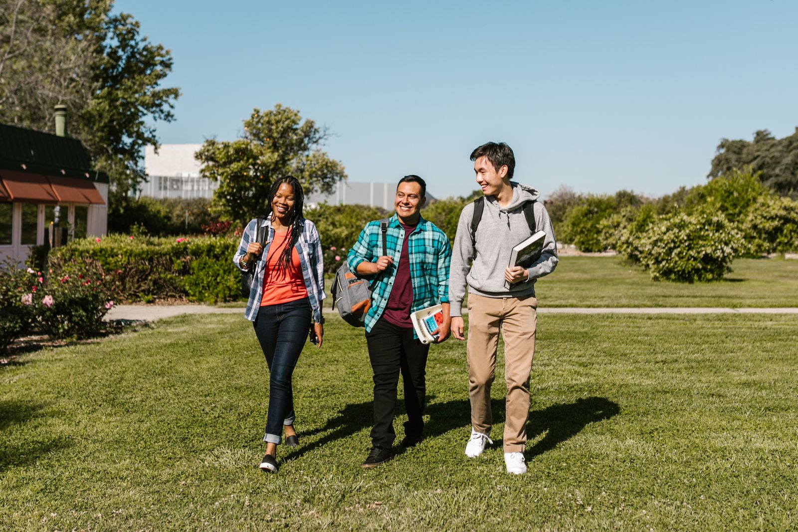 Students walking on a green campus lawn